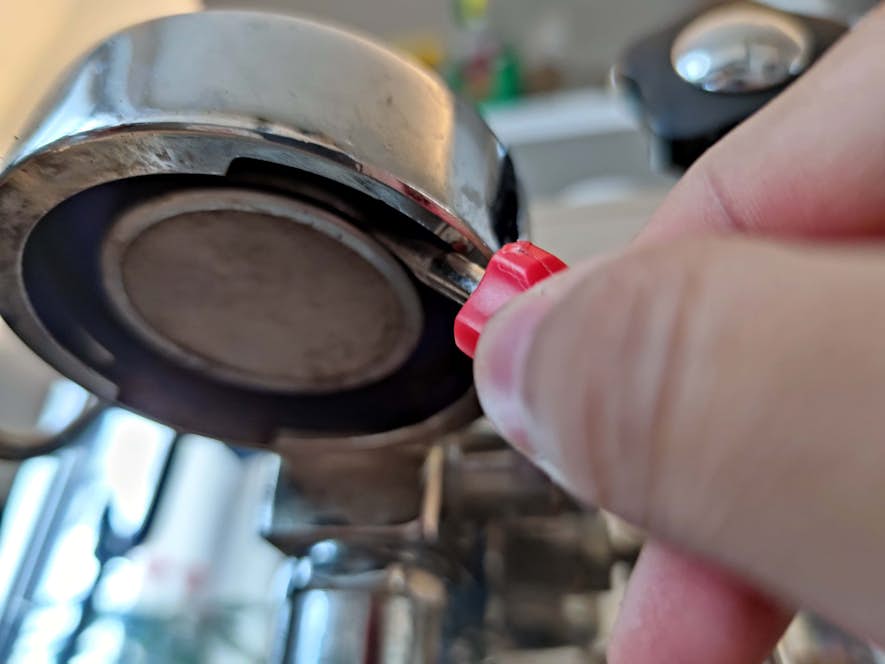 Altes Duschsieb wird mit stumpfem Schraubenzieher herausgehebelt.