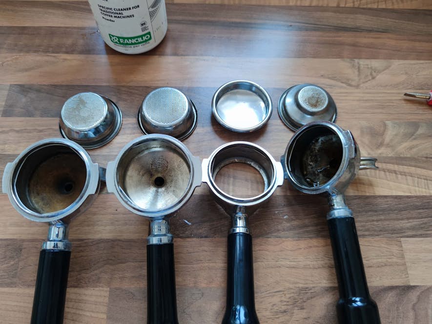 Verschmutzte Siebträger und Duschsiebe vor der Reinigung